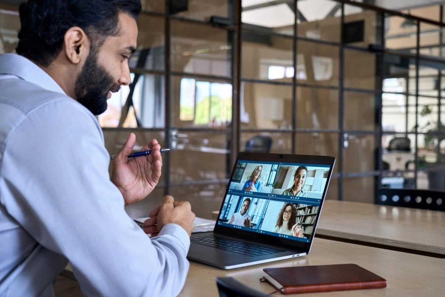 Man in the UAE attending an online professional development video call on a laptop
