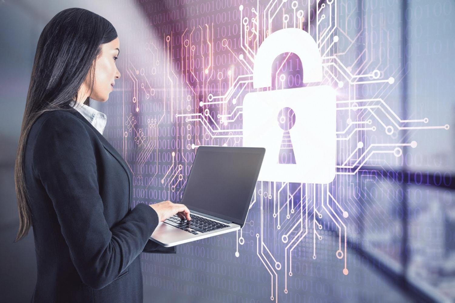Businesswoman using a laptop with a digital padlock and circuit overlay symbolising internal cybersecurity threats